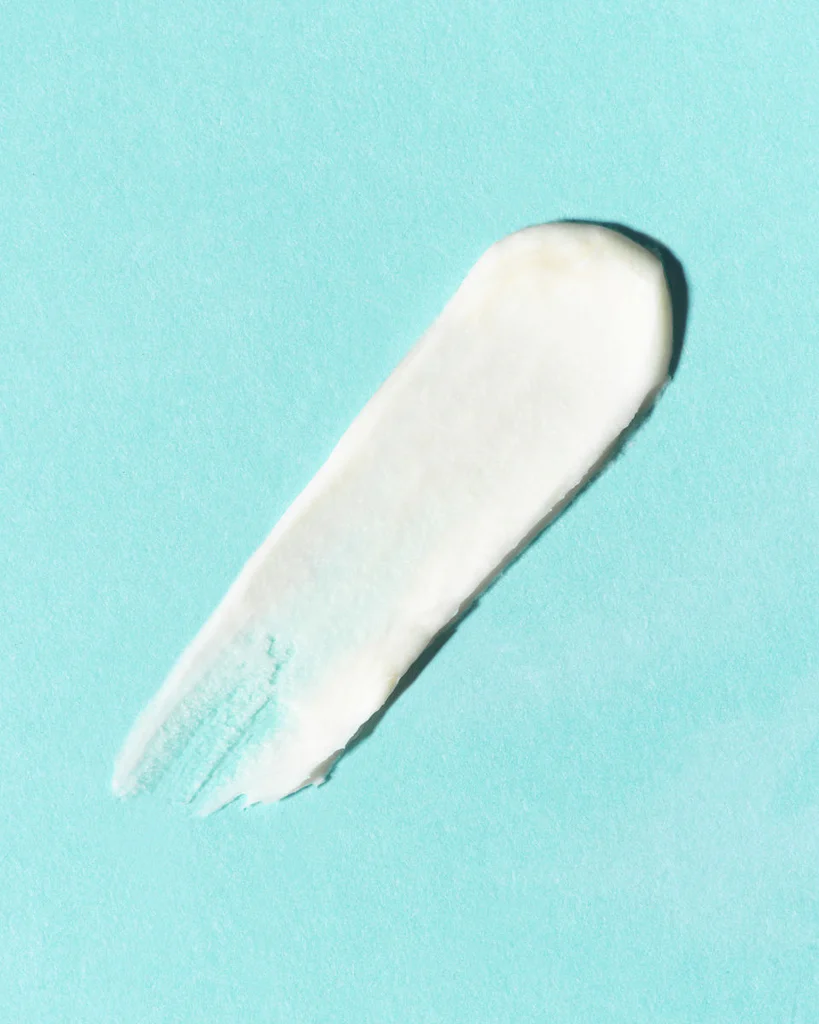 Close-up of a swipe of green skincare
cream on a light blue background.​