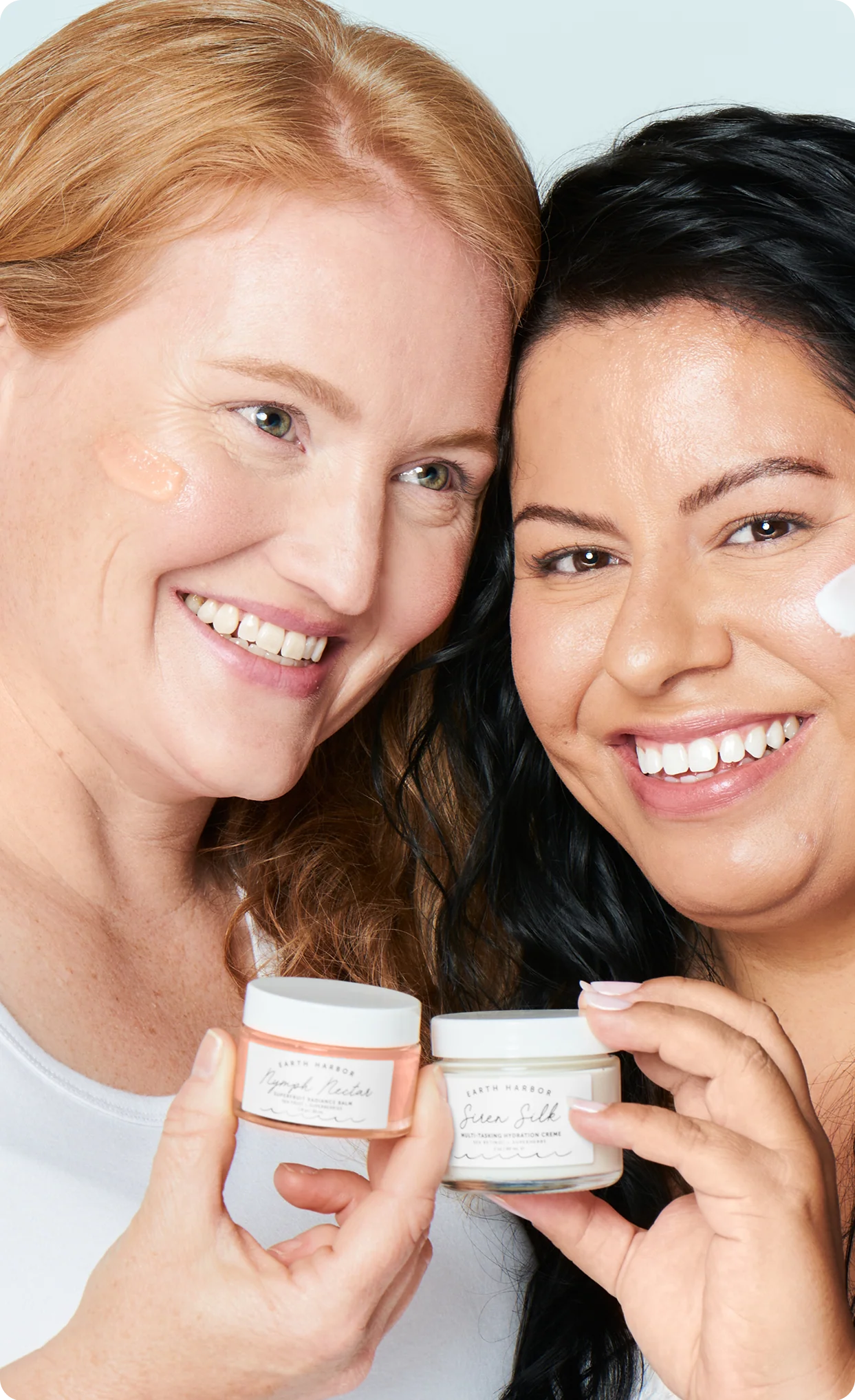 Two women smiling while holding Earth
Harbor skincare jars close to their faces​