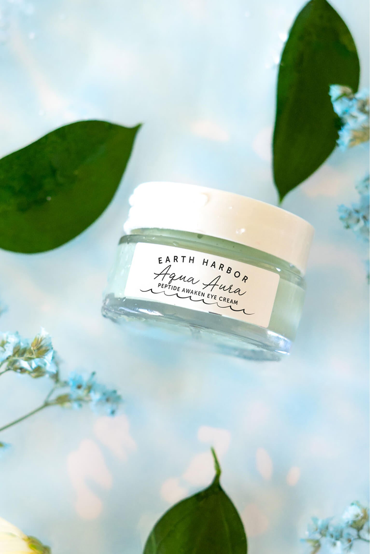 Earth Harbor Aqua Aura jar
floating over bright, rippled blue
water with green leaves and
small flowers.​