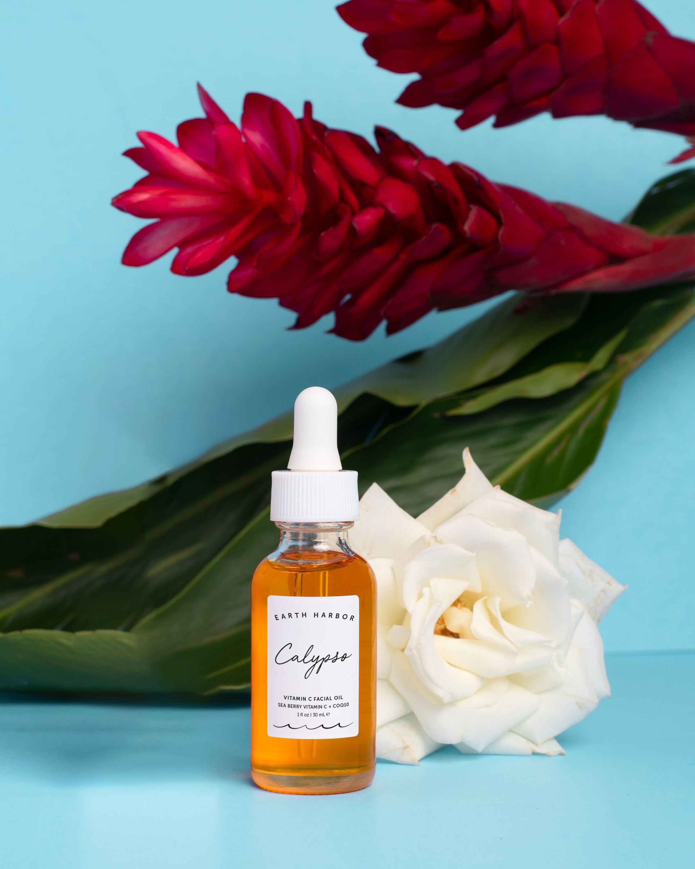 Bottle of Calyseo product with flowers on a blue background