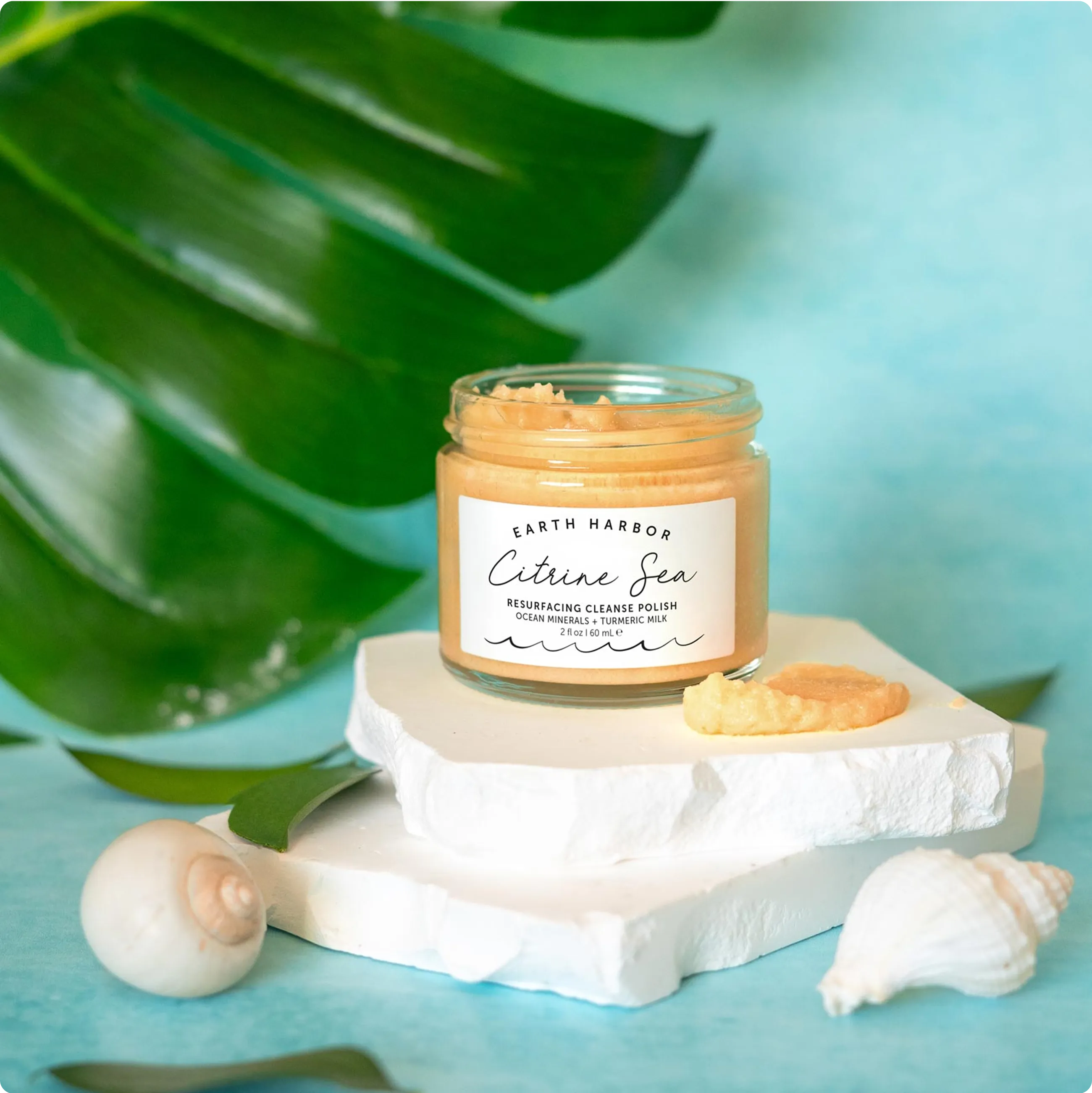 Earth Harbor Nymph Nectar jar floating in
clear blue water with a white starfish and
small seashells.​