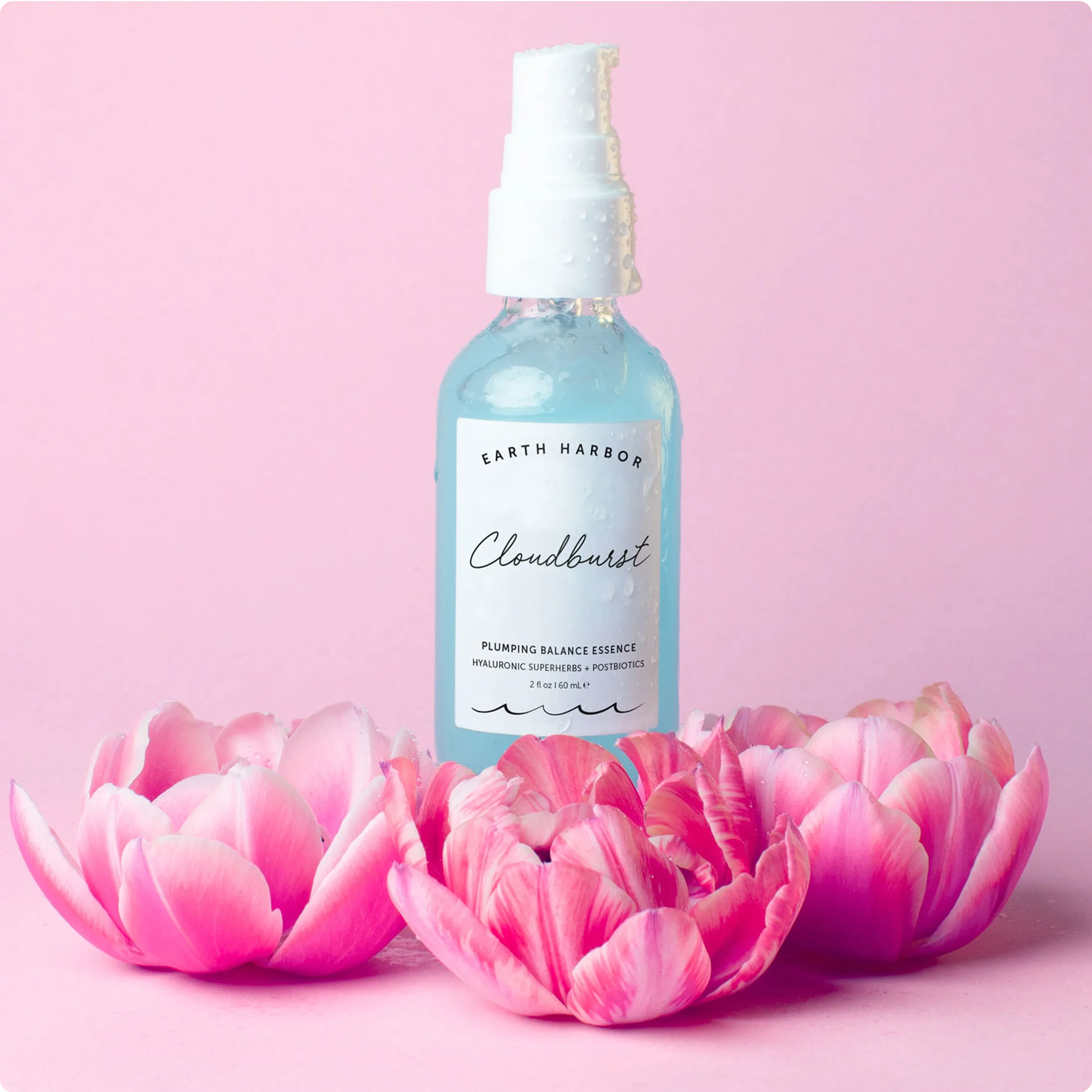 Three blue bottles of Earth Harbor
Cloudburst essence arranged on a blue
background with small white flowers.​