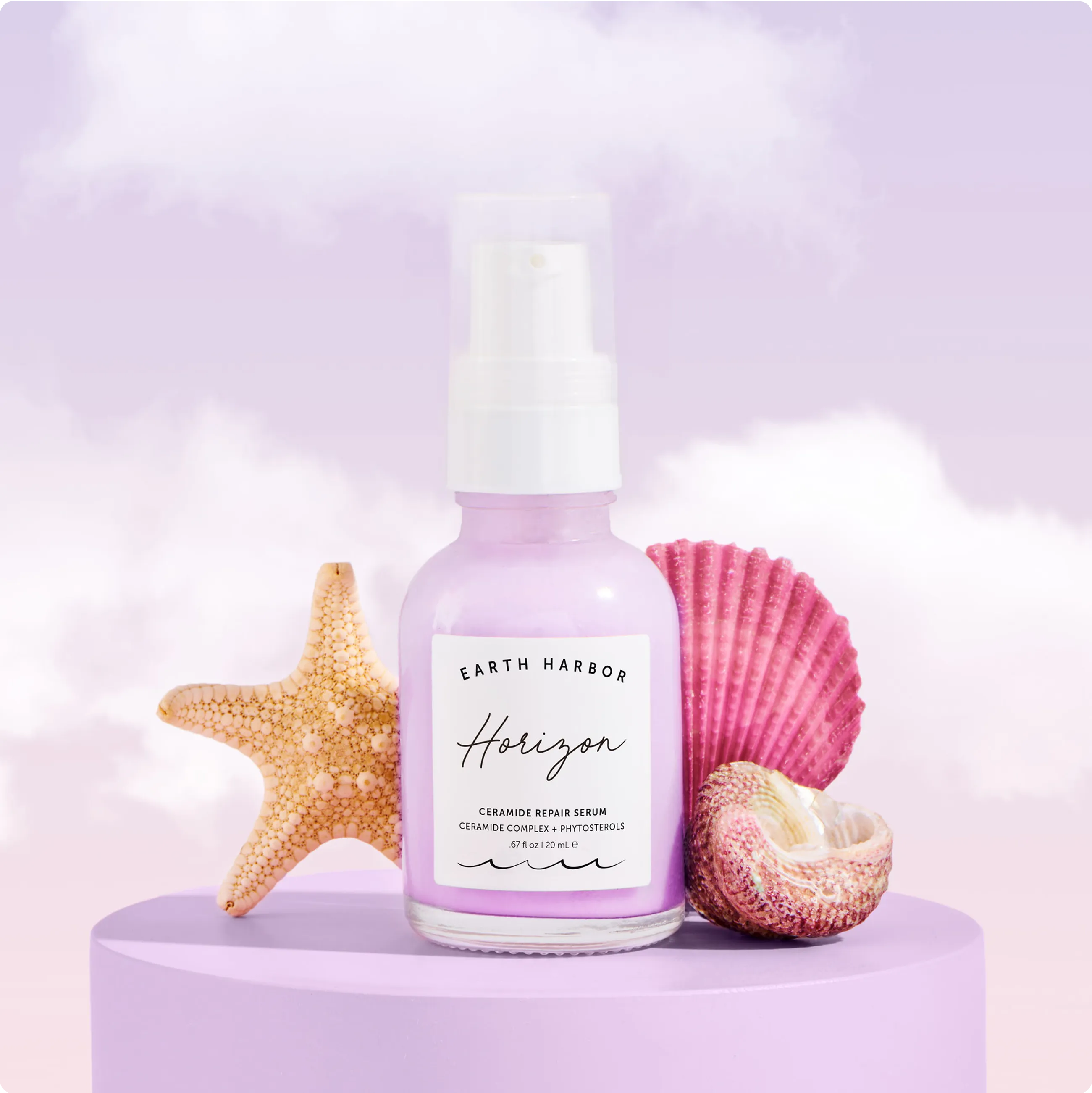 Earth Harbor Horizon serum bottle on a
purple platform next to a starfish and
seashells.​