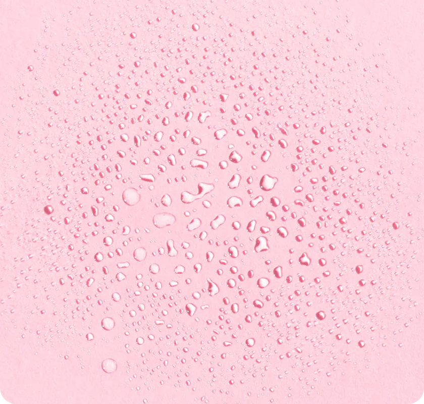 Close-up of water droplets scattered
across a soft pink background​
