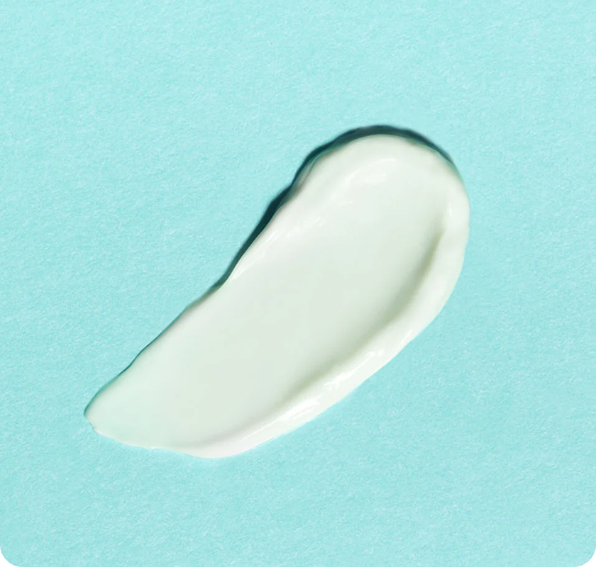 Close-up of a smooth white cream smear
on a light blue background.​