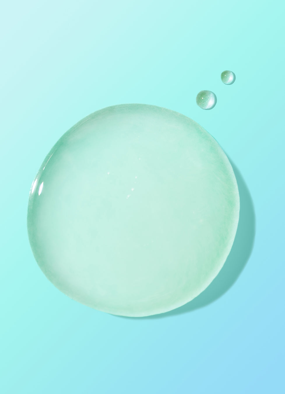 Close-up of a large green gel droplet with
smaller bubbles on a blue background.​