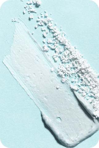 Close-up of a textured swipe of skincare
mask on a light blue background.