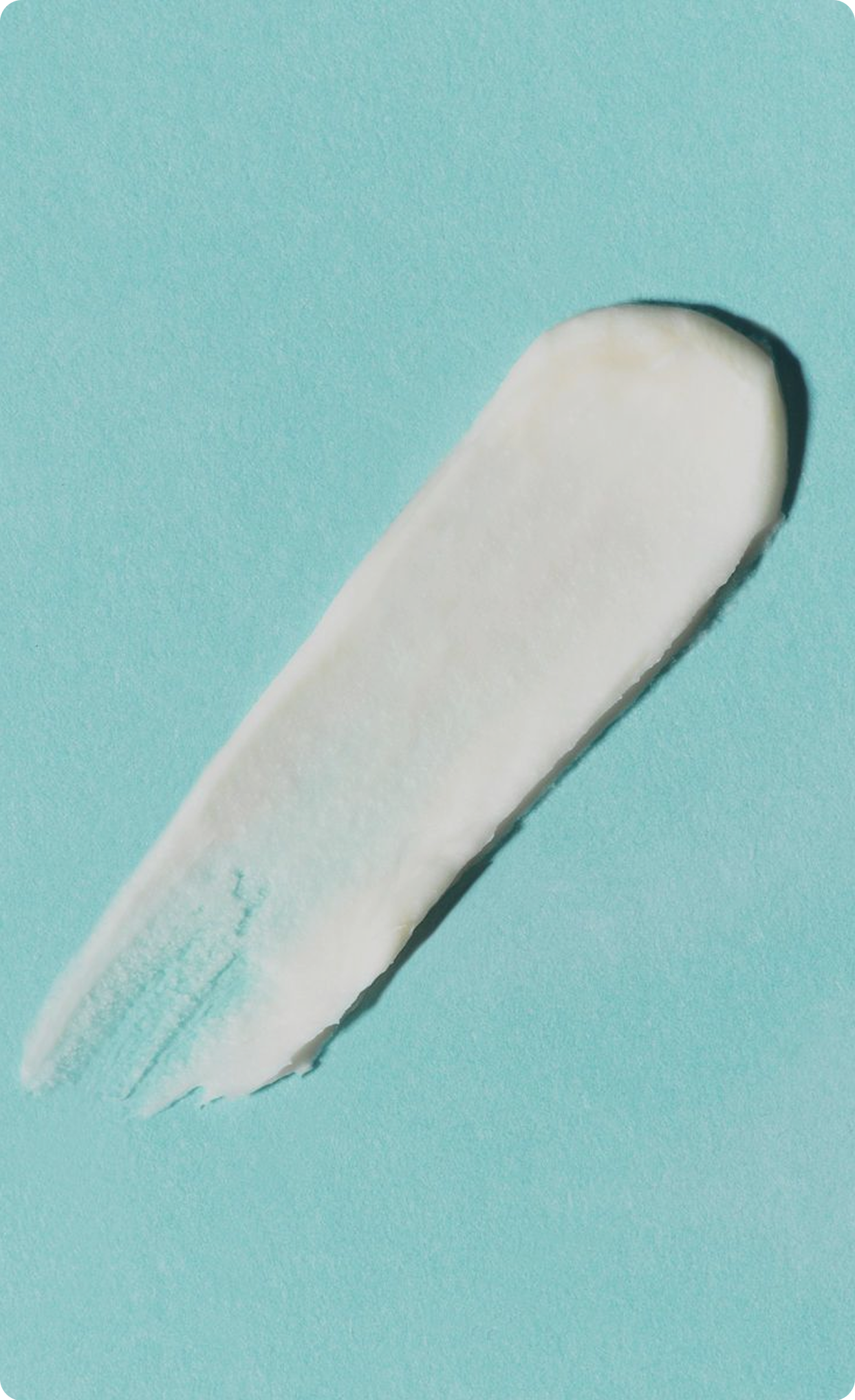 Close-up of a swipe of white skincare
cream on a light blue background.​