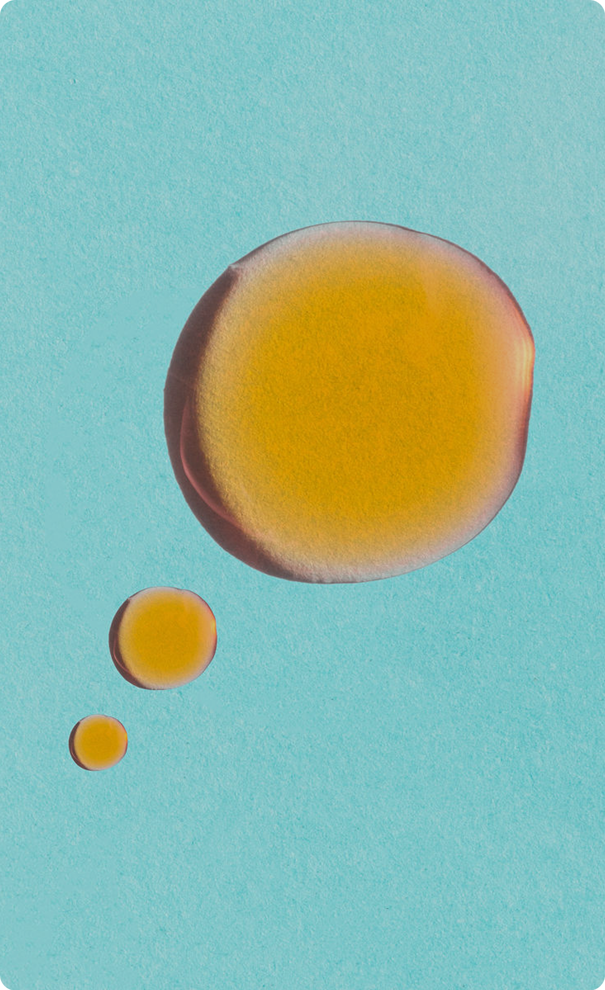 Close-up of orange skincare oil droplets on
a light blue background.