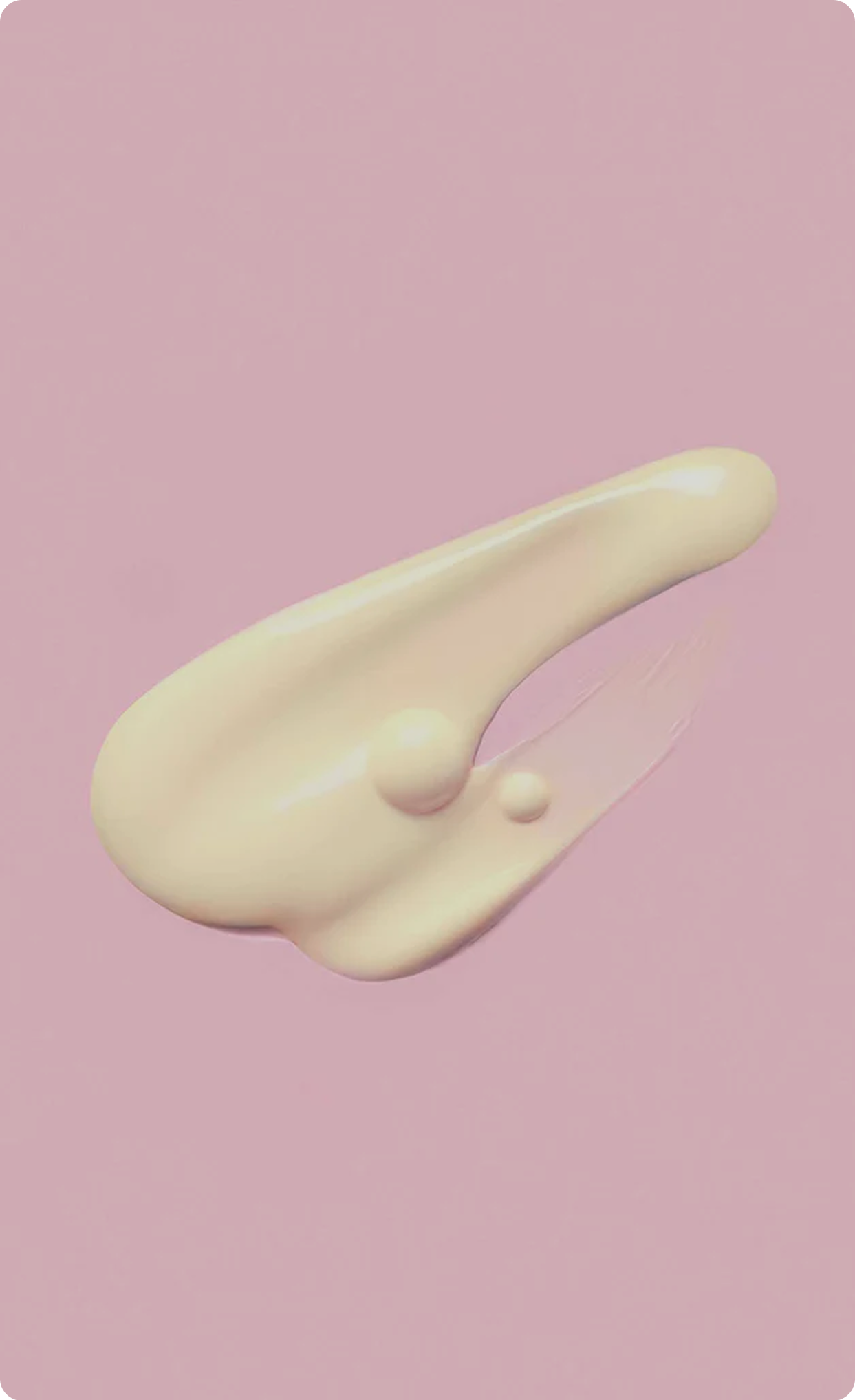 Close-up of a smooth, pale yellow skincare
cream smear on a pink background