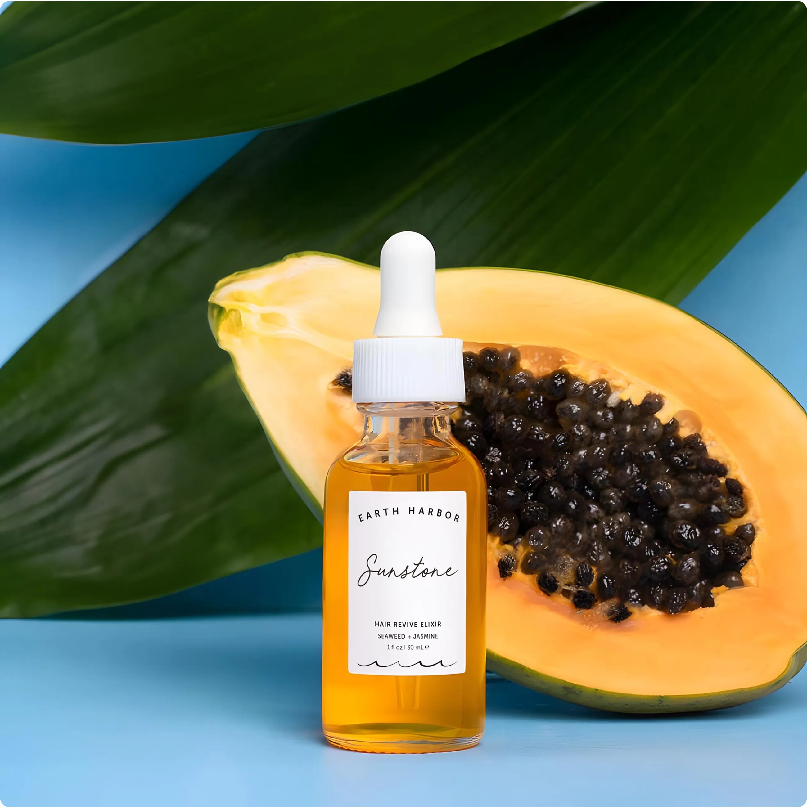 Dropper bottle of Earth Harbor Sunstone
hair elixir next to polished crystals and
yellow flowers.​